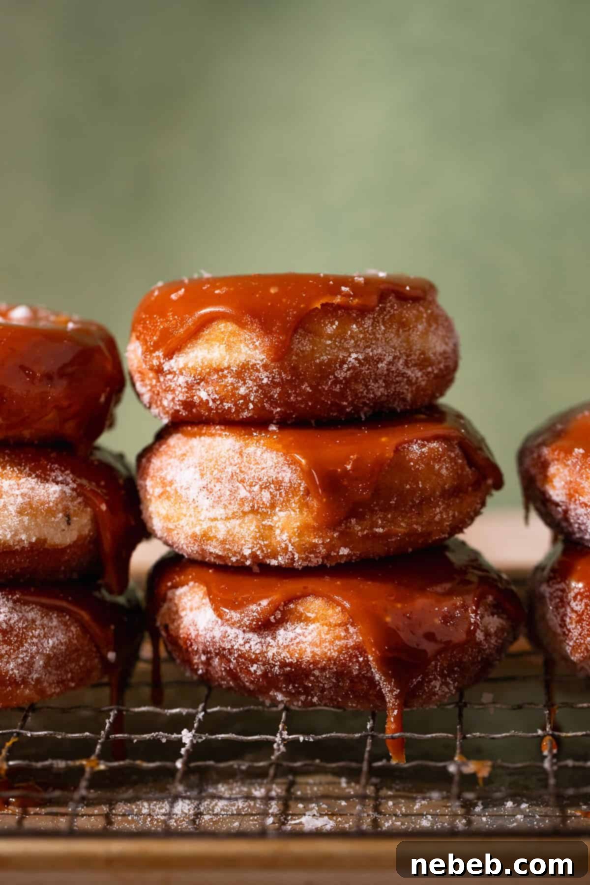Glistening Salted Caramel Doughnuts 11 Three caramel donuts stacked on top of each other dripping with caramel.