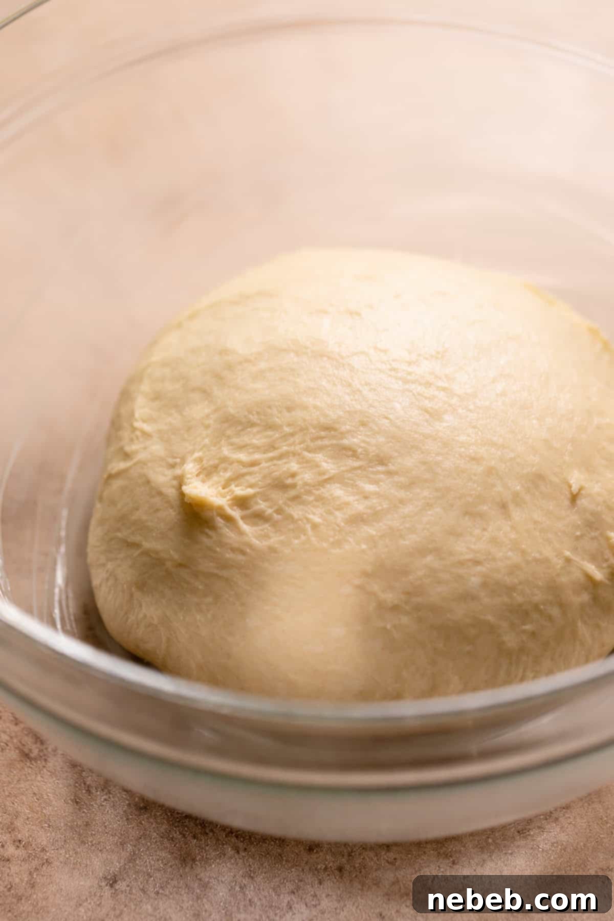 Glistening Salted Caramel Doughnuts 6 A smooth ball of doughnut dough in a glass bowl.
