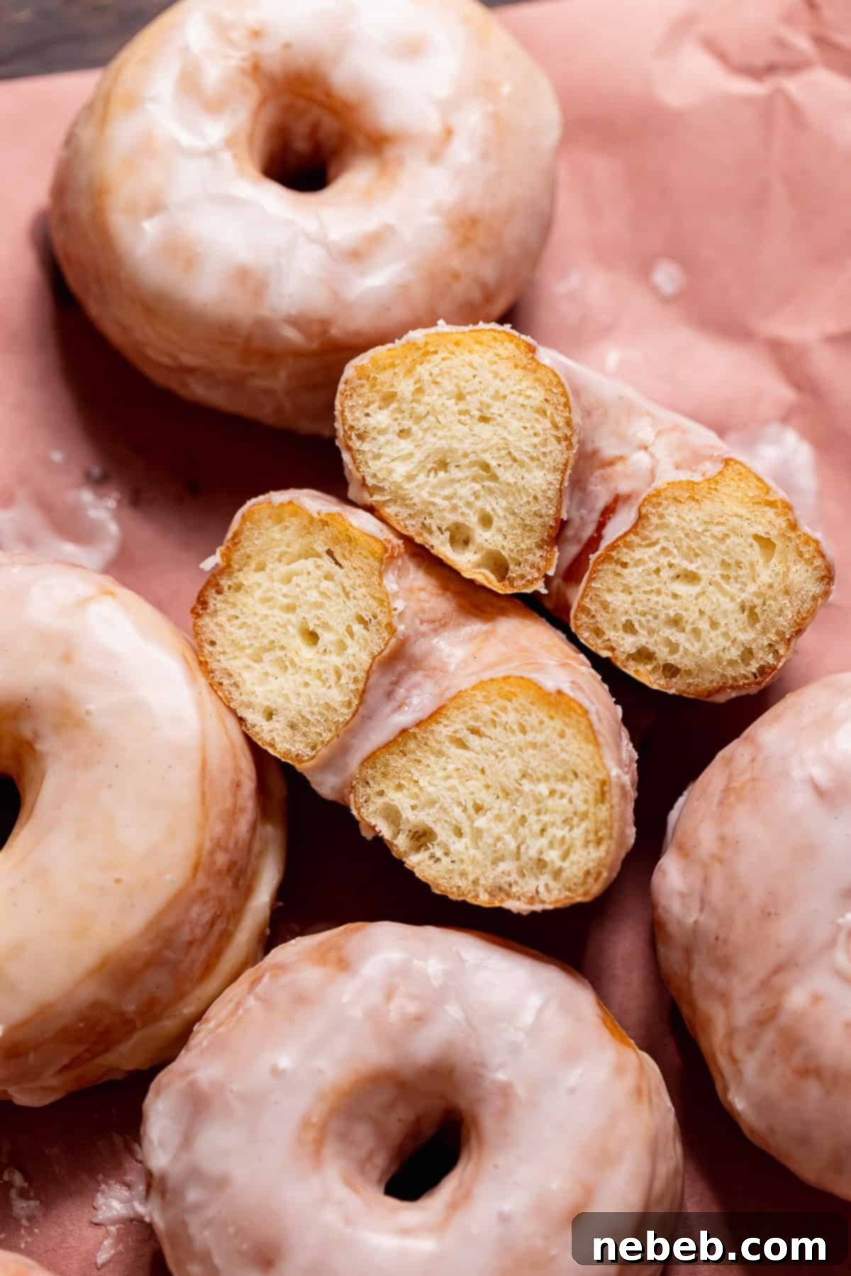 Pillowy Milk Bread Donuts 11 A vanilla glaze donut cut in half on its side showing the soft and fluffy texture.