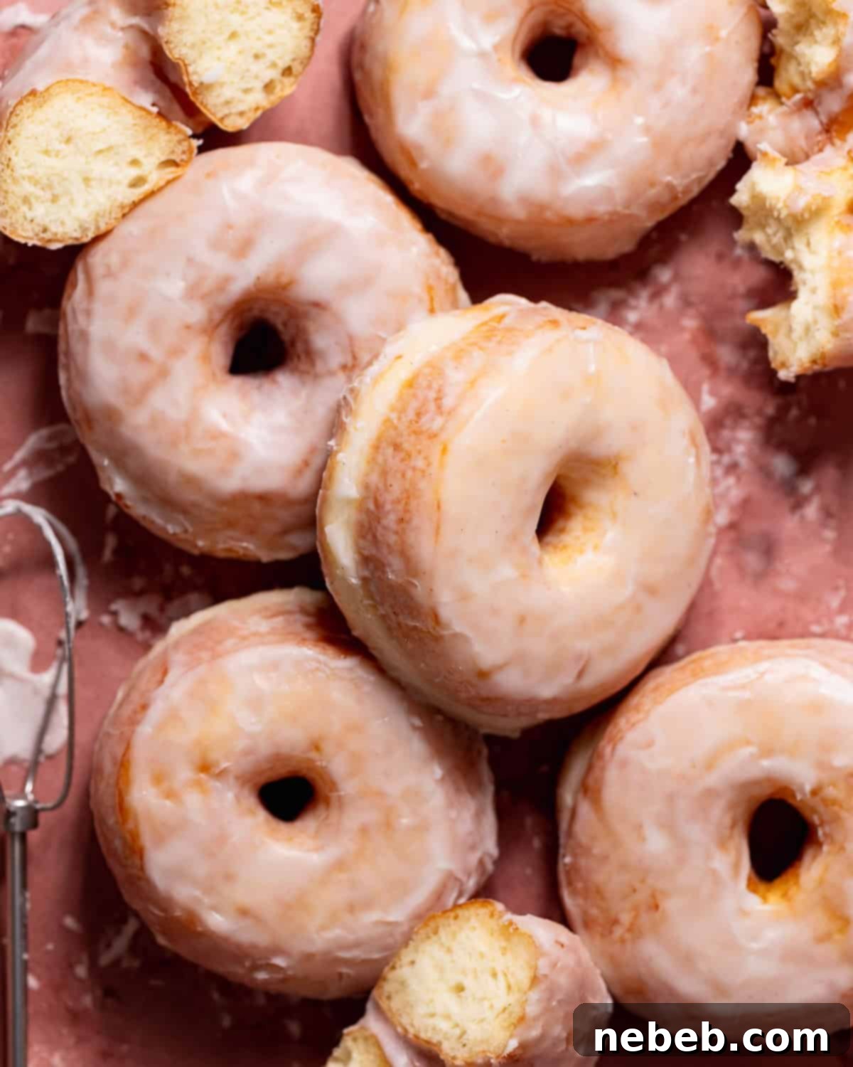 Pillowy Milk Bread Donuts 12 Sugar glazed donuts on pink parchment paper.