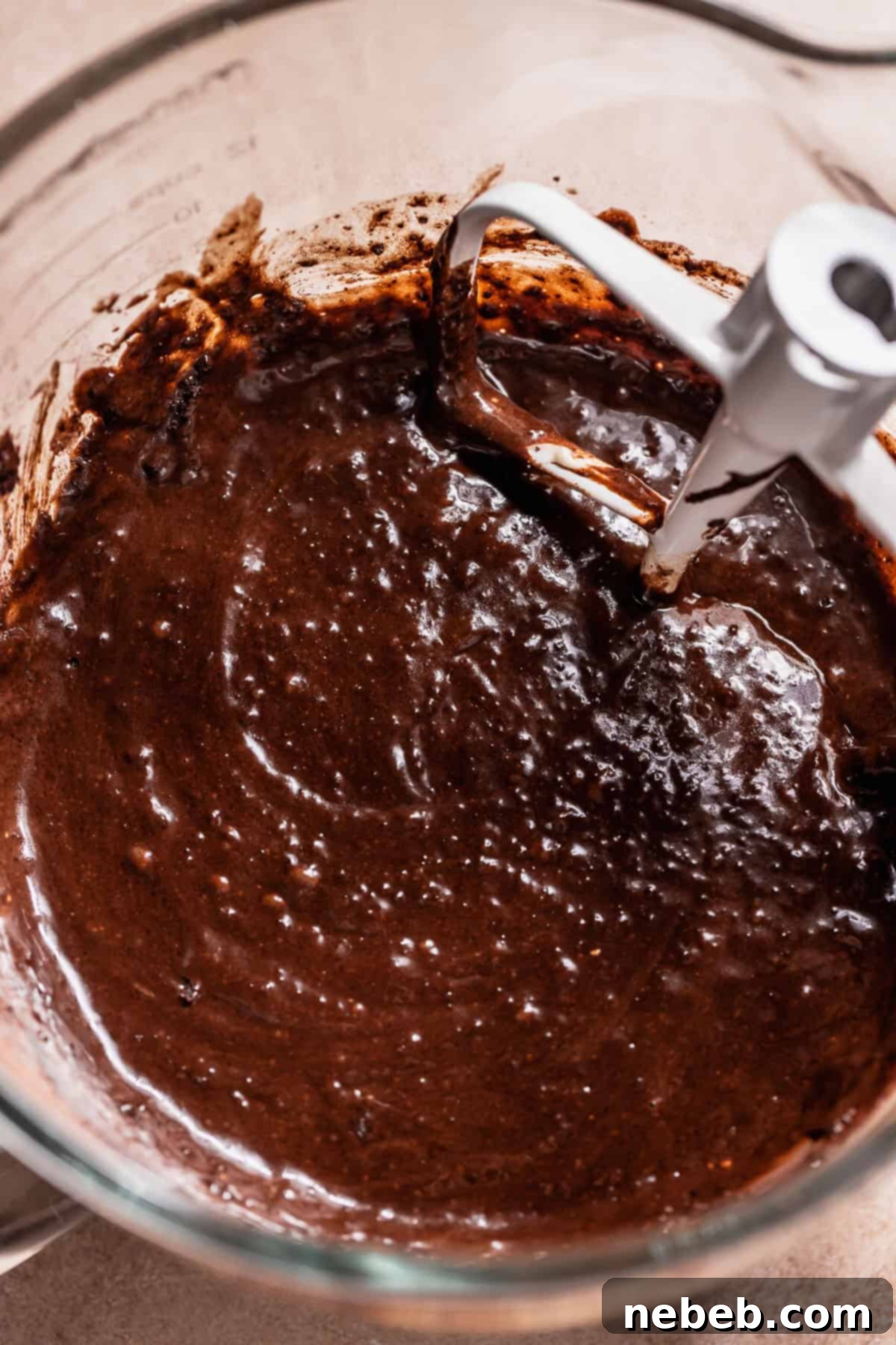 Golden Marshmallow-Stuffed Cocoa Cupcakes 4 Close-up of smooth, dark chocolate cupcake batter in a stand mixer bowl, ready for baking.