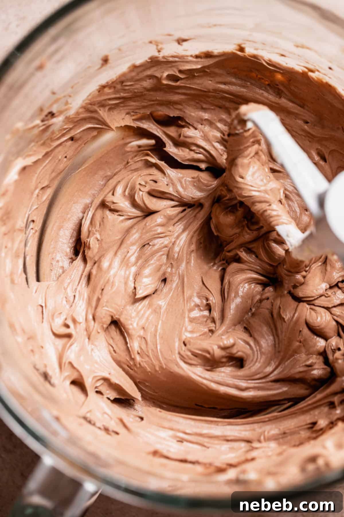 Golden Marshmallow-Stuffed Cocoa Cupcakes 7 Silky smooth milk chocolate buttercream frosting in a glass mixer bowl, ready to be piped onto the hot cocoa cupcakes.