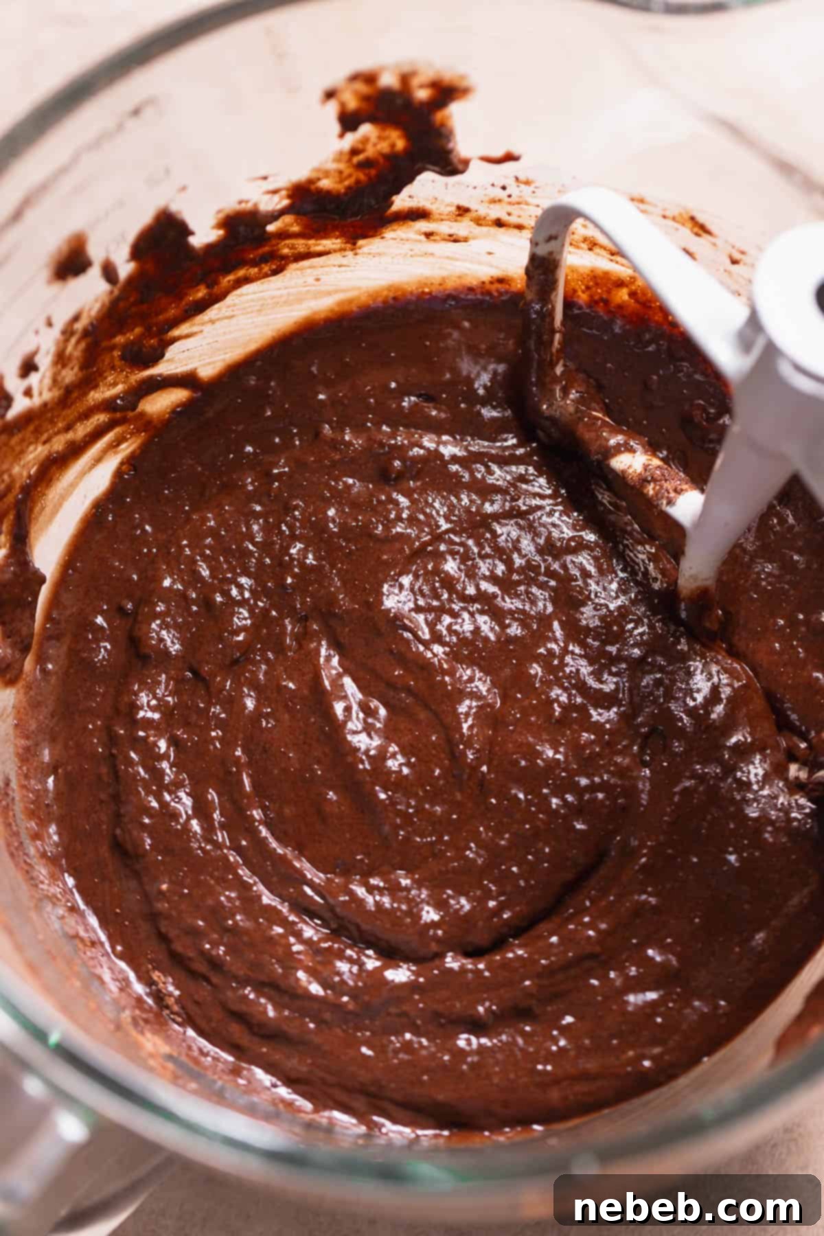 Smooth, glossy dark chocolate cupcake batter after mixing in the wet ingredients, ready for baking.