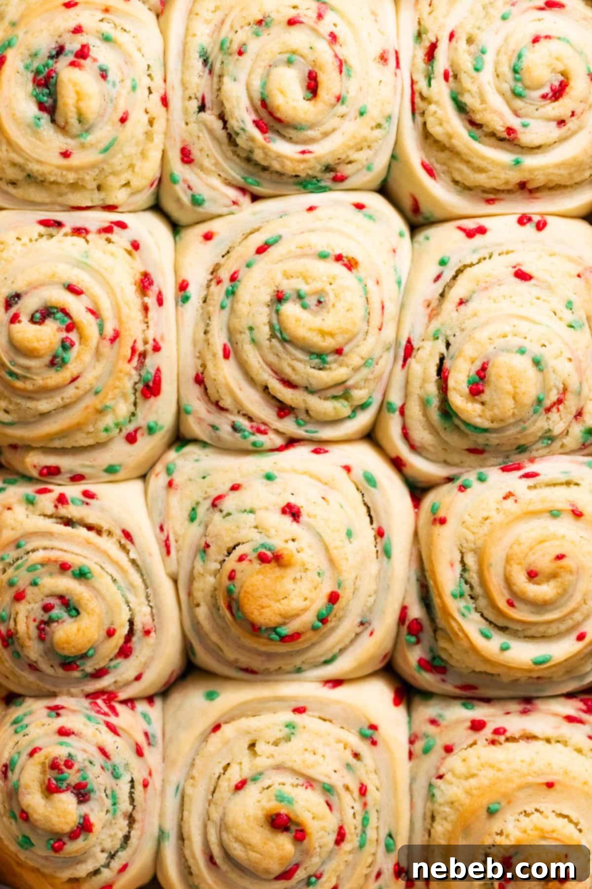 Christmas Swirl Sugar Cookie Bites 7 Baked sugar cookie rolls in a pan, showcasing visible red and green sprinkles before the icing is added.