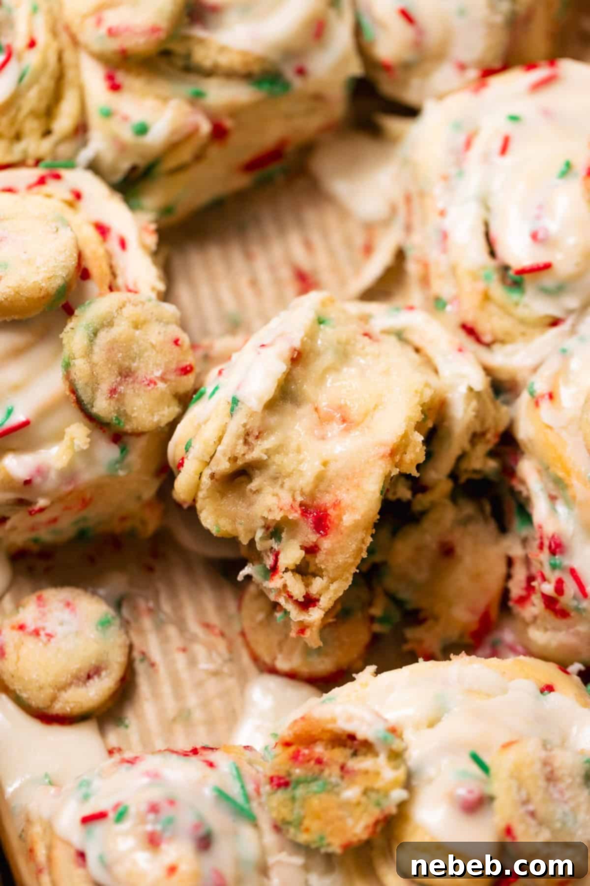 Christmas Swirl Sugar Cookie Bites 9 Close-up shot of a Christmas sugar cookie roll, revealing the gooey sugar cookie filling and the vibrant colors of the holiday sprinkles.
