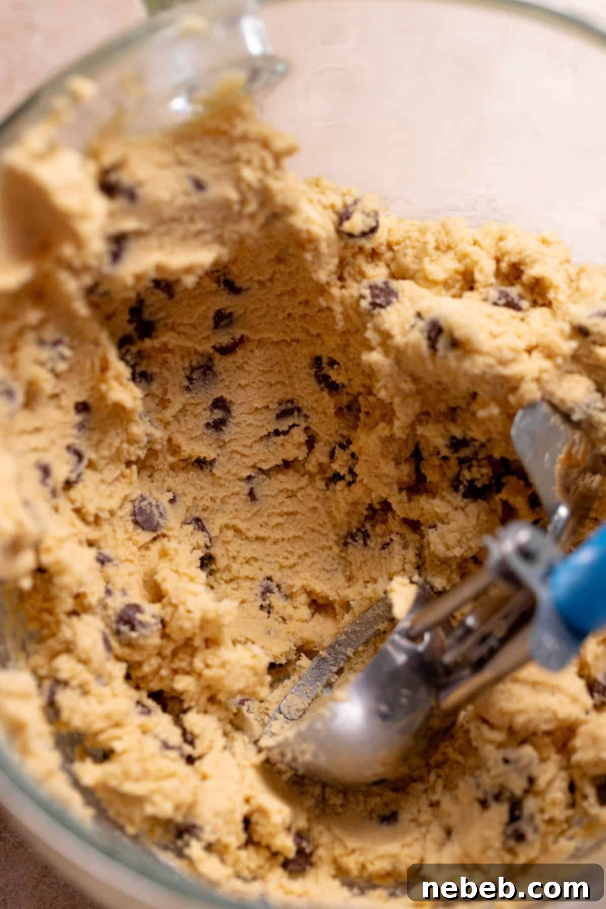 Decadent Chocolate Chip Snickerdoodle Dream Cookies 6 A blue cookie scoop in the mixer bowl with the cookie dough.