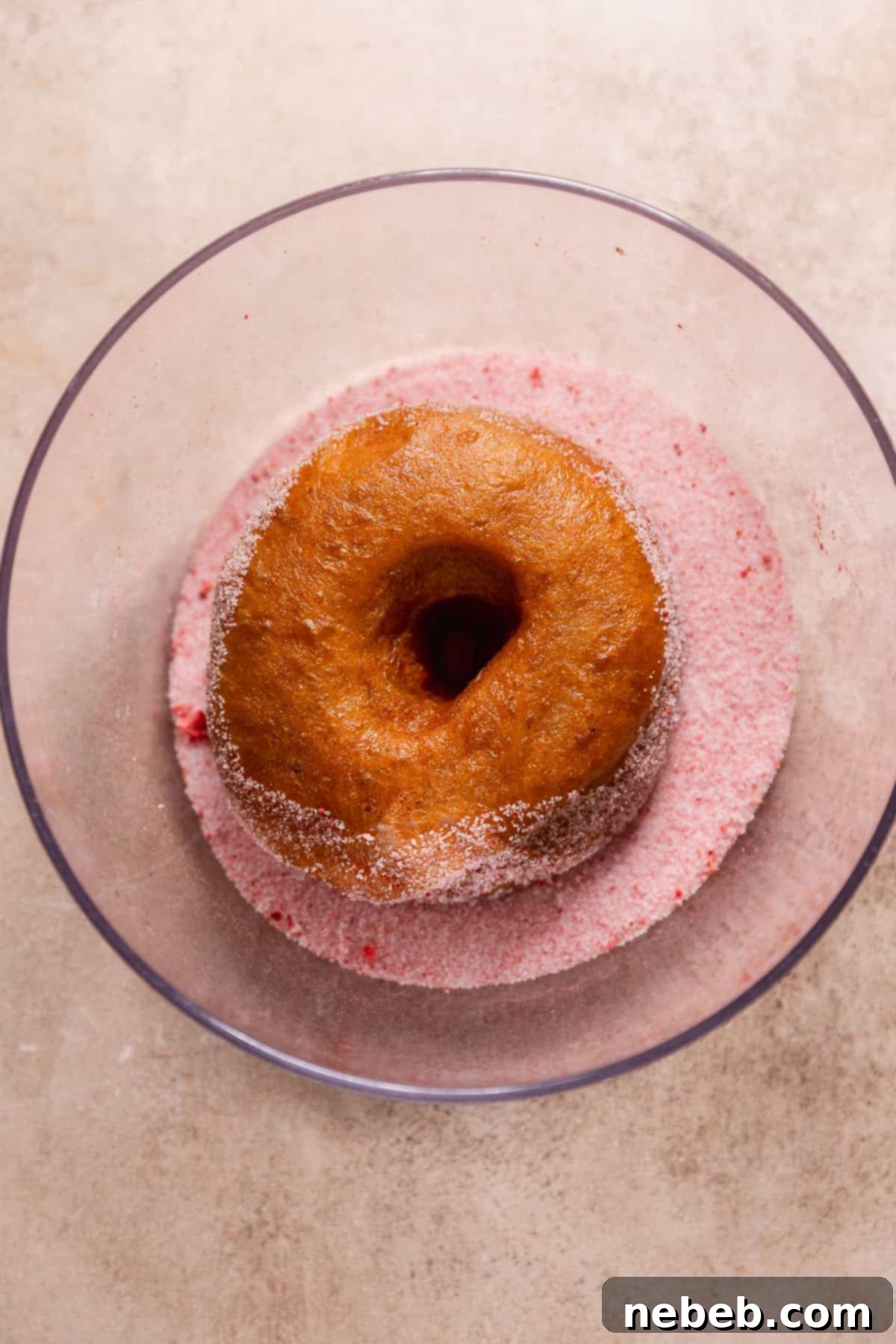 Triple Strawberry Dream Donuts 8 Fried donut coated in strawberry sugar inside a bowl.